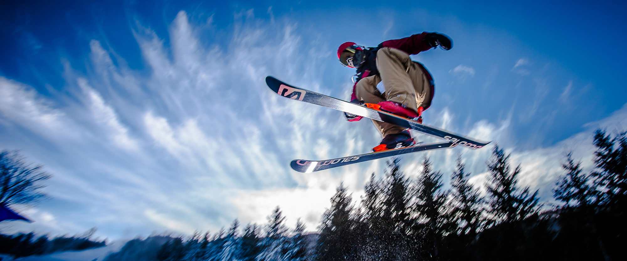 Skier jumping in the air at the Beech Mountain Resort with blue sky in the background